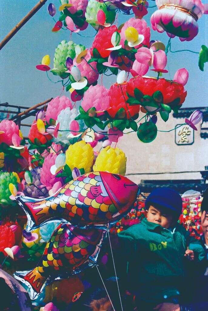 1990年大人带着娃娃逛灯市，选一盏花灯过元宵节。王松南 摄
