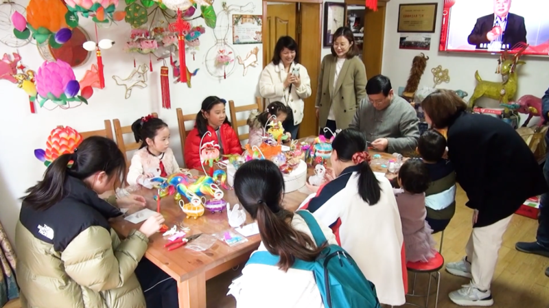 孩子们向灯彩艺人学习做花灯。