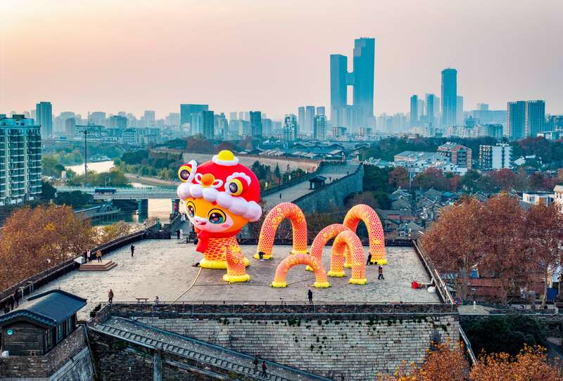 南京中华门城墙上，高16米Q版的蛇宝宝灯彩与城市建筑同框。